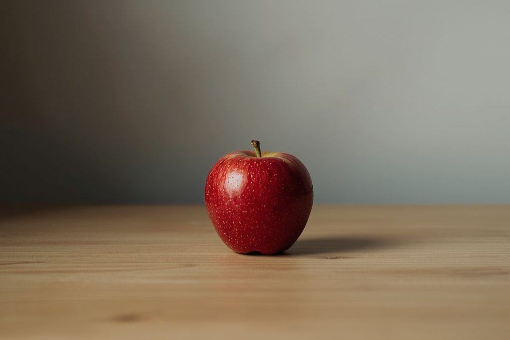 A single red apple on a plain background for red kasina meditation